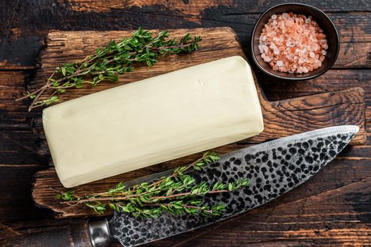 Butter Spread block on a wooden board. Dark wooden background. Top view.