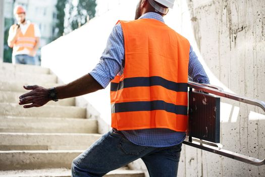 Professional builder carrying metal ladder, close up photo