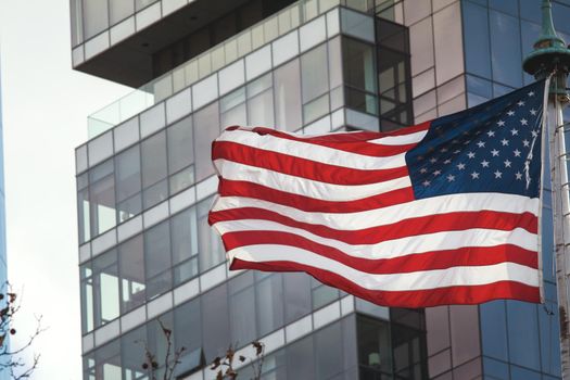 American flag on the background of the glass building, NYC, USA