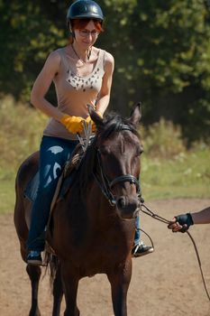 Horseback riding lessons - young woman riding a horse, telephoto shot