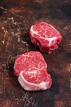 Raw Fillet Mignon tenderloin steaks. Dark background. Top view.
