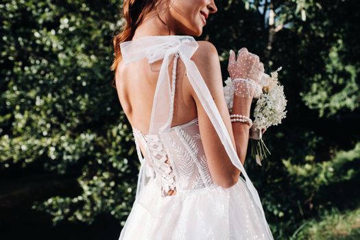 portrait of an elegant bride in a white dress with a bouquet in nature in a nature Park.Model in a wedding dress and gloves and with a bouquet .Belarus.