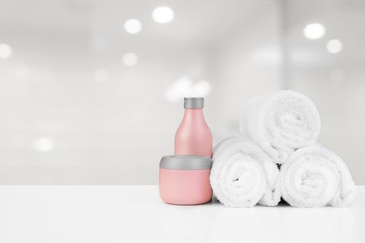 Spa still life with towels and skincare cosmetics against blurred background, close up