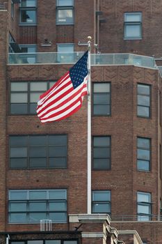 American flag on the brown brick building, NYC, USA