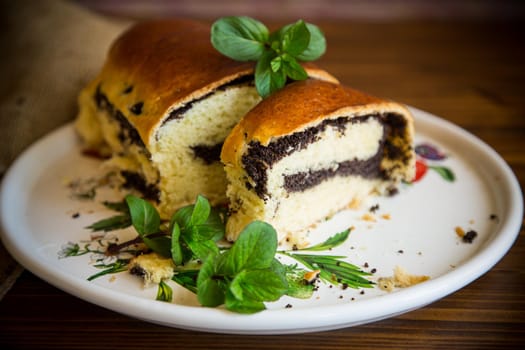 sweet pastries, roll with poppy seeds inside on a wooden table.