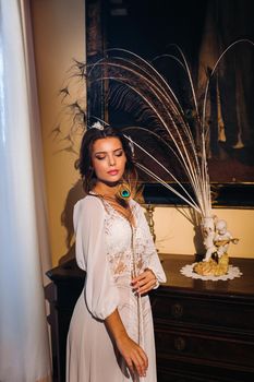 a bride in underwear and a white robe in the interior of a Villa in Italy at a wedding.morning of the bride in Tuscany.boudoir photo session at the Villa