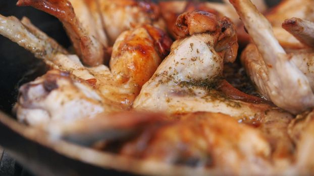 Close up view of Frying Chicken wings preparing in boiling oil - spatula stirring food, telephoto