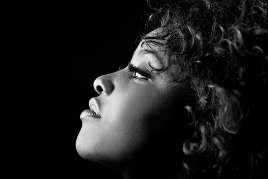 Close up portrait of beautiful black woman on black background with red hair. Afro hairstyle. Studio shot