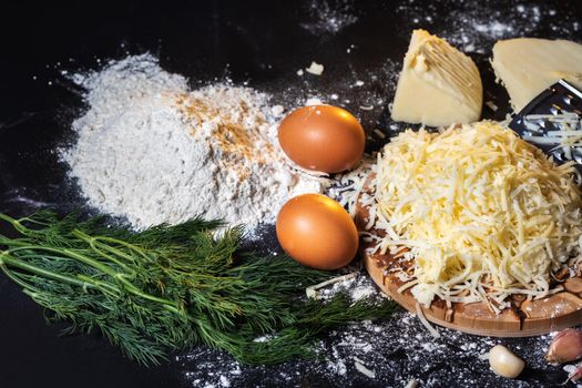 preparation of the process of cooking cheese balls with garlic and dill on a black background.