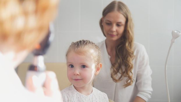 Child's ophthalmology - check up of eyesight - optometrist diagnosis little girl, close up
