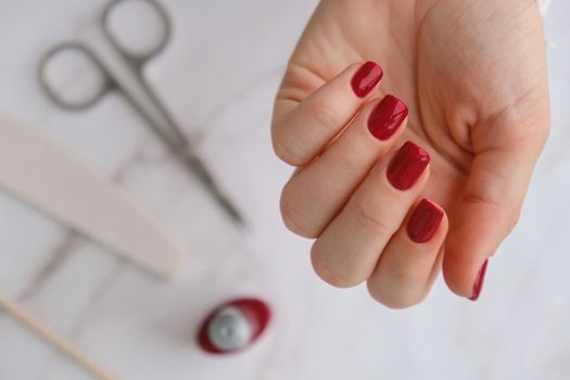 Stylish red female nails. Modern Beautiful manicure. Autumn winter nail design concept of beauty treatment. Gel nails. Skin care. Wellness. Trendy colors.