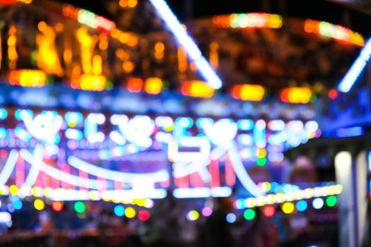 Defocused bright lights flash at a fun carnival at night. Amusement Park Bokeh Lights at Night. Nightlife entertainment background