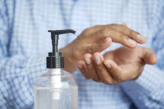 close up of young man hand using sanitizer gel for preventing virus.