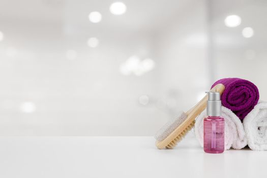 Spa still life with towels and skincare cosmetics against blurred background, close up