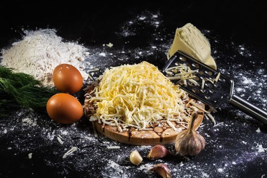 preparation of the process of cooking cheese balls with garlic and dill on a black background.