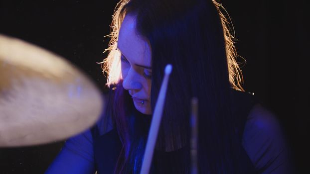 Young woman percussion drummer performing with drums, close up