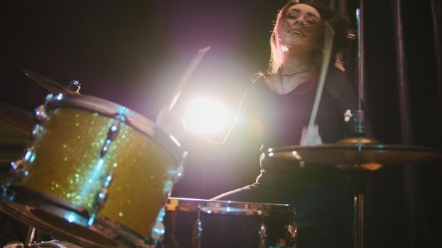 Gothic girl percussion drummer perform music break down - Rock band rehearsing in the garage, telephoto