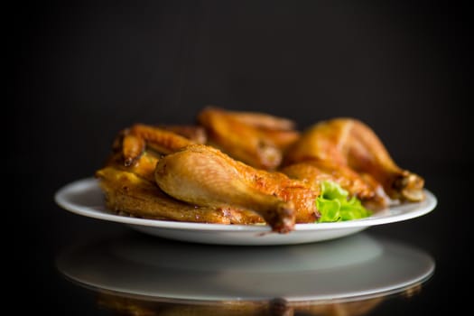 whole fried chicken in a plate on a black background