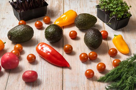 Assorted vegetables lying on a wooden table.