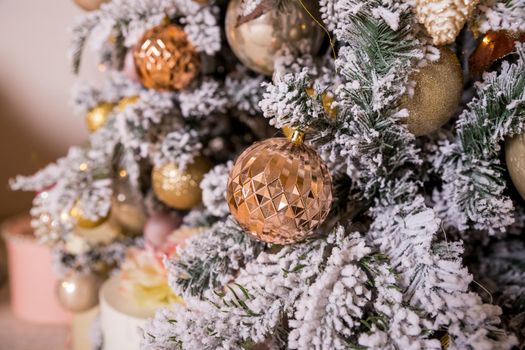 Christmas tree decorated with toys in silver and pink color. In it we see the balloons with of ribbons, stick figure deer, beads