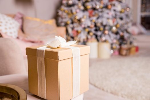 Presents and Gift boxes under Christmas Tree. Beige boxes with ribbon bow. New year decorated house interior. Winter Holiday concept.