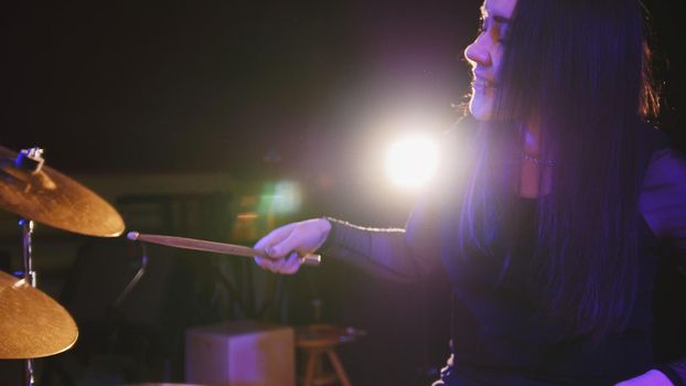 Girl rock musician - female drummer performing, telephoto