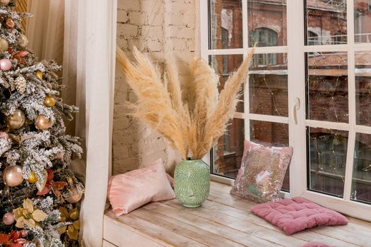 Big bunches of cotton standing in vases and hand made wooden wreaths by the window at the florist shop