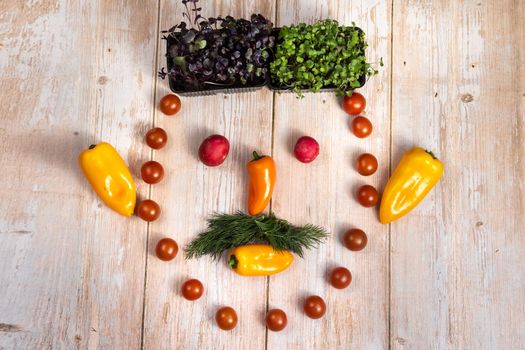 The face of a man made of sliced vegetables on a wooden background.