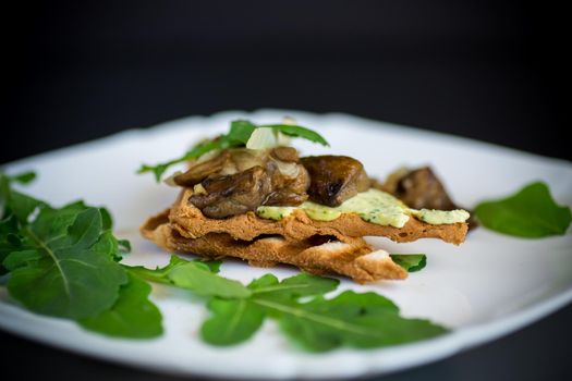 fried toast with cheese spread, arugula and fried mushrooms isolated on black background