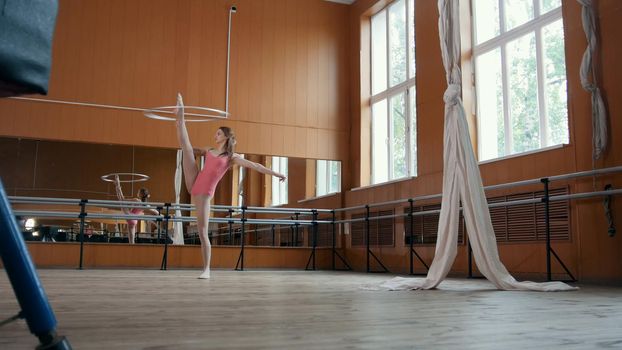 Graceful girl ballerina practicing in the Studio, elements of acrobatic, telephoto