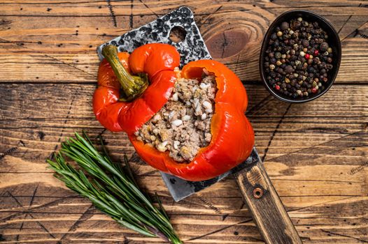 Roasted sweet bell pepper with meat, rice and vegetables. wooden background. Top view.