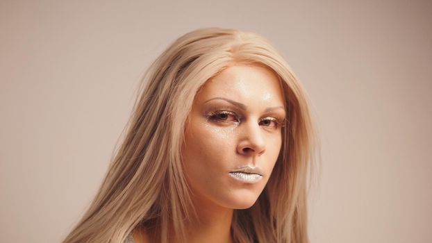 Blonde model posing for photographer in studio, telephoto