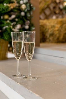 Two glasses of champagne with lights in the background. very shallow depth of field, focus on near glass.