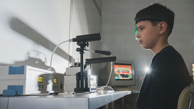 Ophthalmology clinic - child checks eyes vision with high technology device, close-up