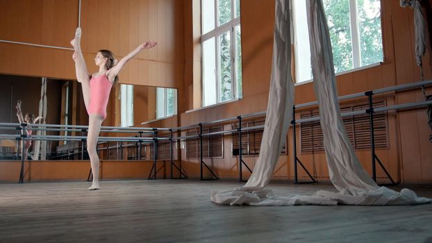 Beautiful girl shows amazing flexibility of the legs of the ballet bar, circus artist