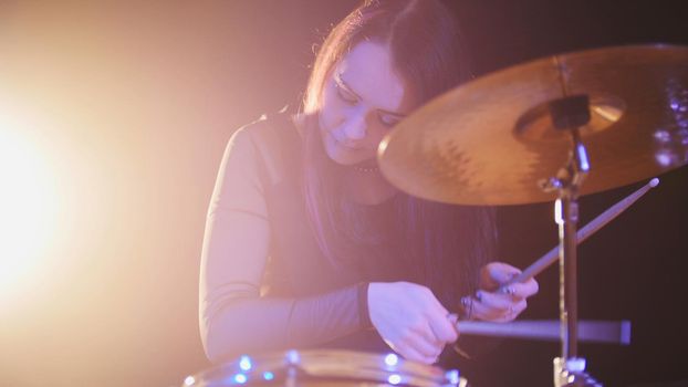 Teen garage rock music - attractive girl percussion drummer perform music break down, horizontal