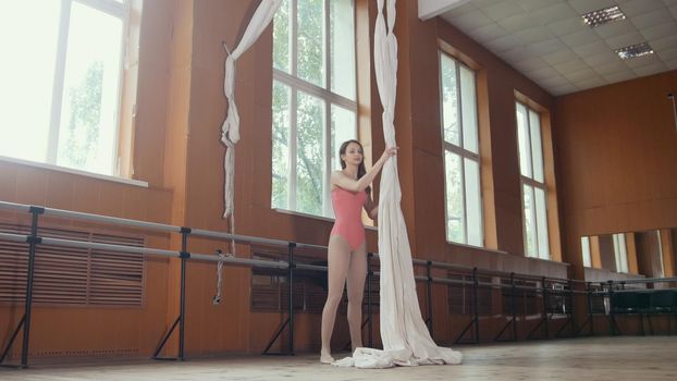 Portrait of a young gymnast girl in ballet room, wide angle