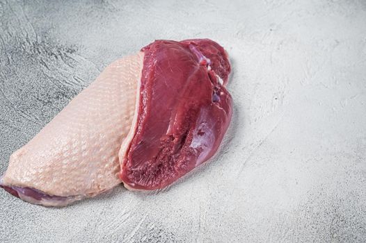 Raw uncooked Duck breast fillet steaks on butcher table. White background. Top View. Copy space.