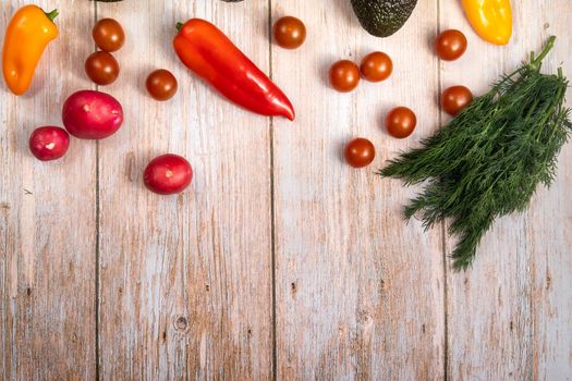 Assorted vegetables lying on a wooden table.