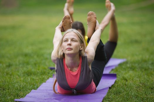 A group of yogis in a graceful pose during outdoor pursuits, summer