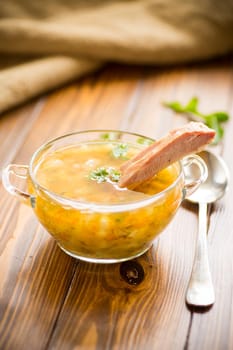 cooked pea soup with ribs smoked in a plate on a wooden table