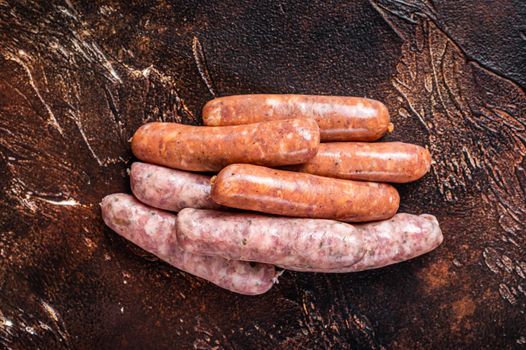 Raw barbecue sausages Chorizo and Bratwurst with spices. Dark background. Top View.