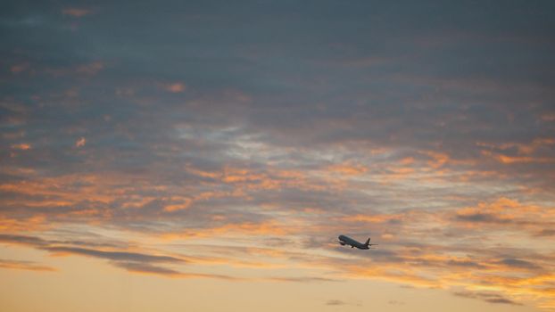 Passanger aircraft takes off into sky from international airport, sunset