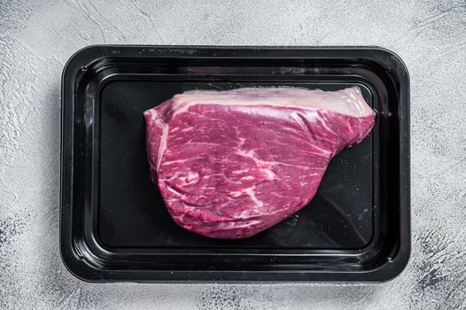Raw cap rump steak or top sirloin beef meat steak in vacuum packaging. White background. Top view.