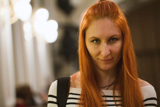 Portrait of attractive red hair girl in theatre, telephoto