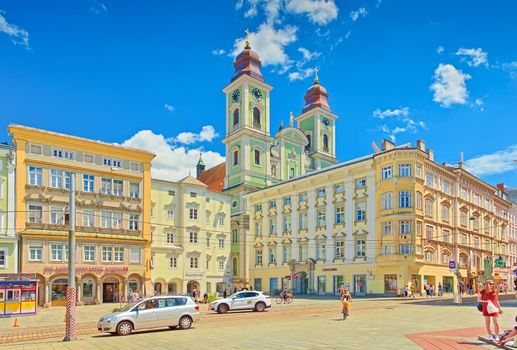 Linz - June 2020, Austria: View of the Main Square of Linz with colorful historical buildings and the Old Cathedral (the Church of Ignatius)