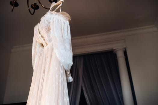 Vintage Wedding dress hanging on a wooden hanger.