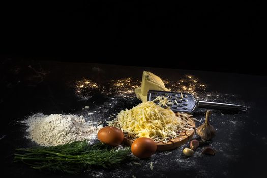 preparation of the process of cooking cheese balls with garlic and dill on a black background.