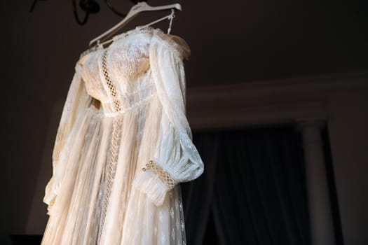 Vintage Wedding dress hanging on a wooden hanger.