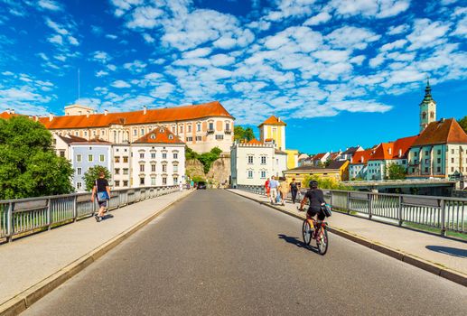 Steyr - June 2020, Austria: A man is riding a bike across the bridge towards the center of the beautiful Austrian city of Steyr